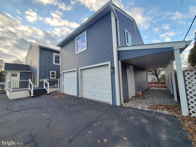 view of side of home featuring a carport, a garage, and a deck