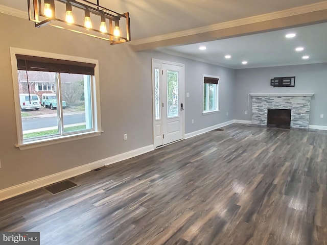 unfurnished living room with ornamental molding, dark hardwood / wood-style floors, and a stone fireplace