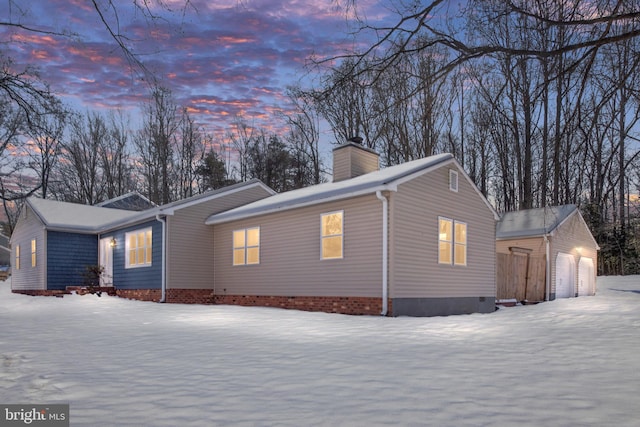 view of snow covered exterior with a garage