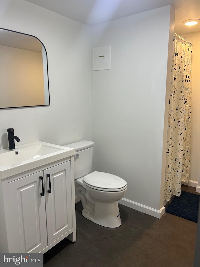 bathroom featuring toilet, walk in shower, and vanity