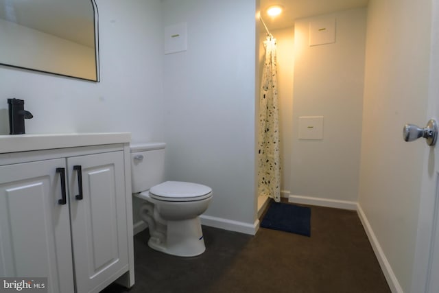 bathroom featuring toilet, vanity, and a shower with curtain