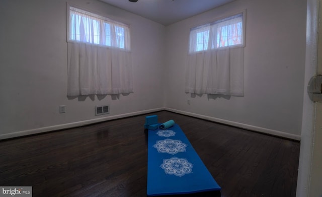 empty room with plenty of natural light and dark hardwood / wood-style floors