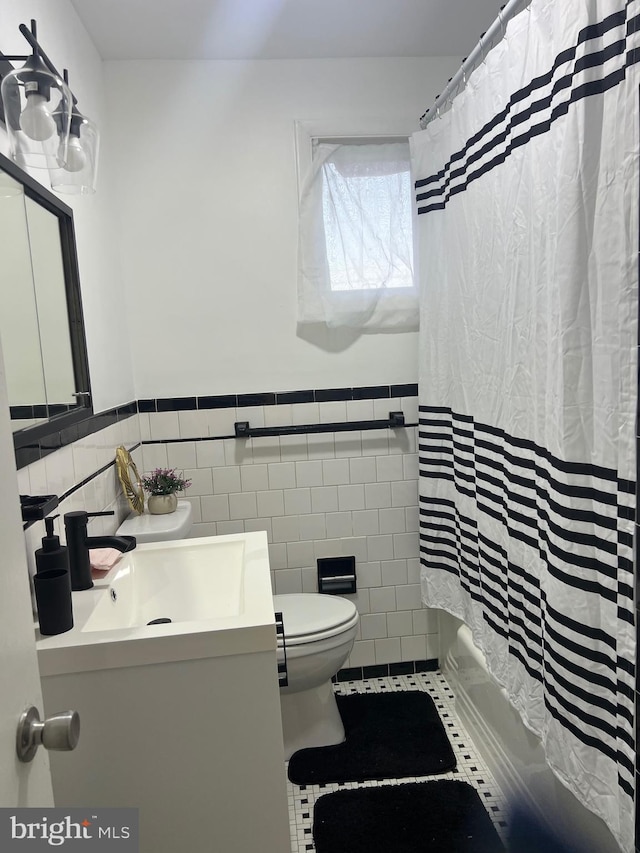 full bathroom featuring toilet, tile walls, shower / bath combination with curtain, tile patterned floors, and vanity