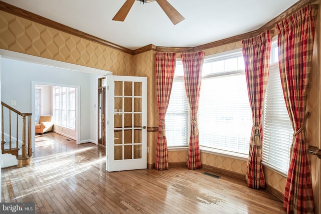 unfurnished room featuring crown molding, plenty of natural light, hardwood / wood-style floors, and ceiling fan