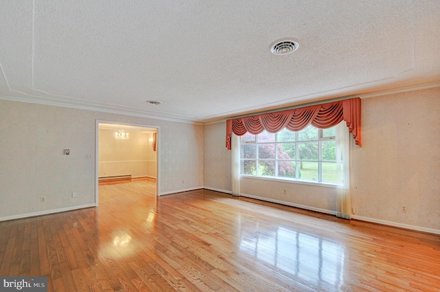 unfurnished room with a textured ceiling, light wood-type flooring, and crown molding