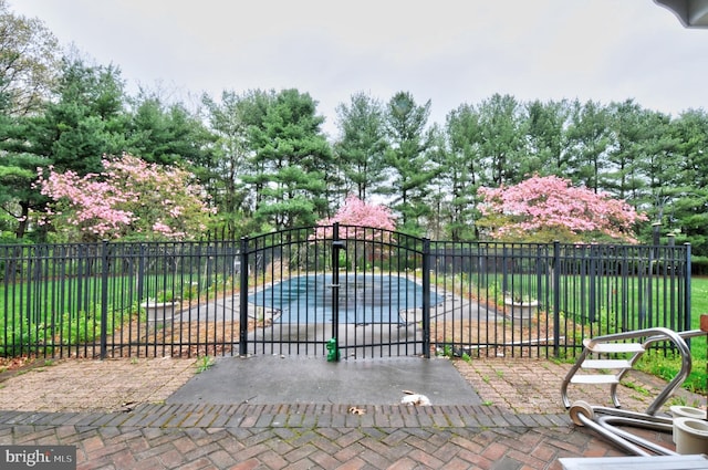 view of gate with a patio and a covered pool