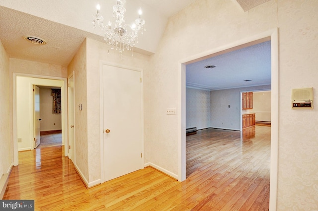 corridor with crown molding, a chandelier, and wood-type flooring