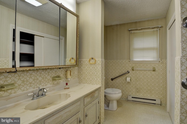 bathroom featuring vanity, a textured ceiling, toilet, and a baseboard heating unit