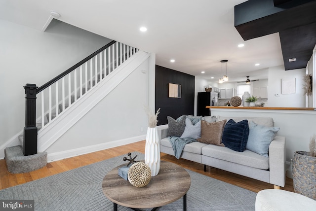 living room featuring hardwood / wood-style flooring and ceiling fan