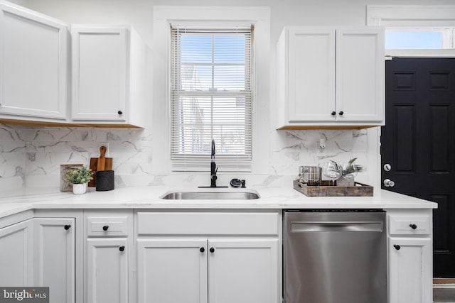 kitchen with backsplash, dishwasher, white cabinetry, and sink