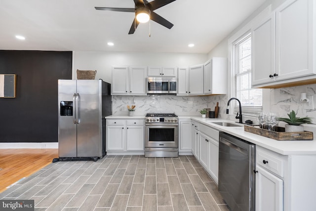 kitchen featuring white cabinets, sink, appliances with stainless steel finishes, tasteful backsplash, and light hardwood / wood-style floors