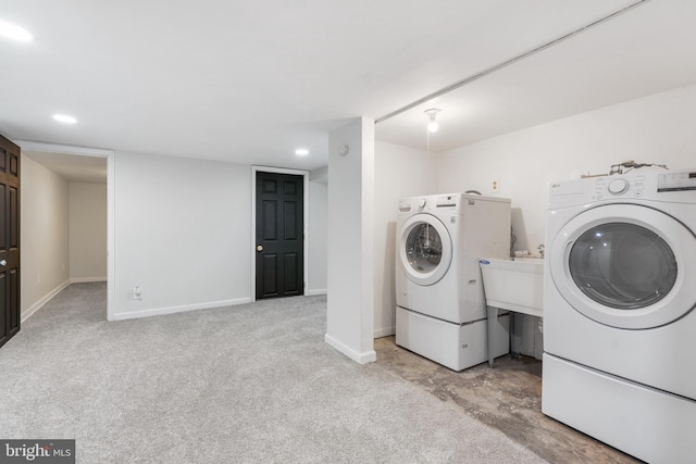 clothes washing area with washer and dryer and light colored carpet