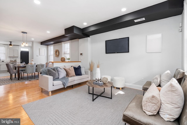 living room featuring ceiling fan and light hardwood / wood-style flooring