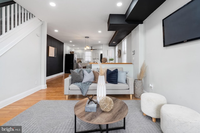 living room featuring ceiling fan and light hardwood / wood-style floors