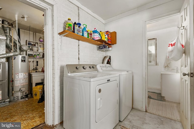 clothes washing area with washing machine and dryer and water heater