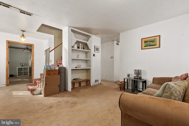 living room featuring built in shelves and carpet