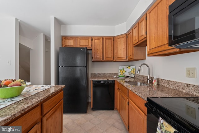 kitchen featuring stone counters, sink, and black appliances