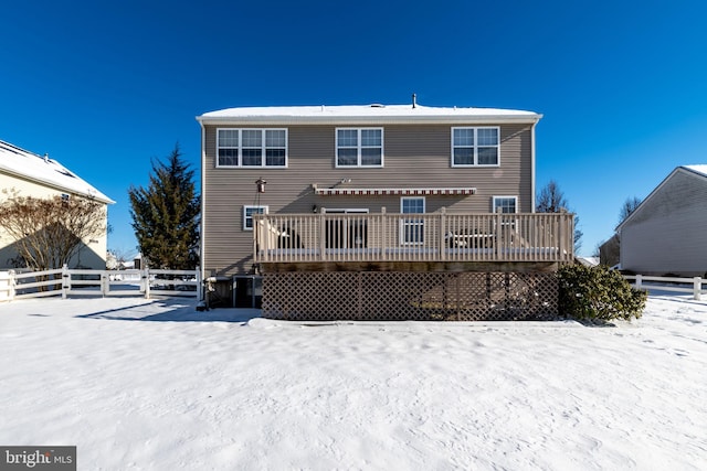 snow covered house featuring a wooden deck