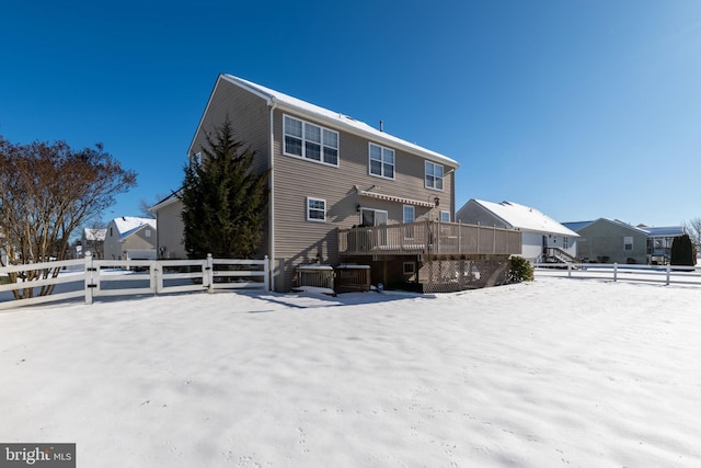 snow covered rear of property featuring a deck