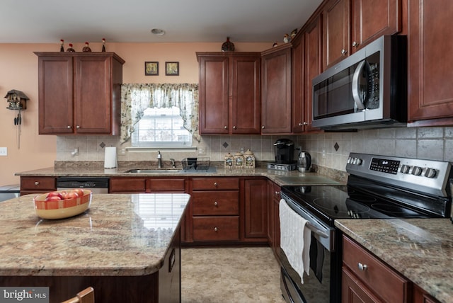 kitchen featuring light stone countertops, appliances with stainless steel finishes, and sink