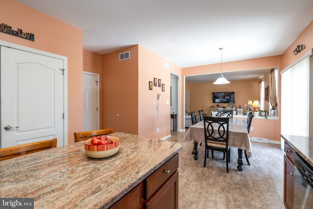 kitchen featuring light stone counters, stainless steel dishwasher, and decorative light fixtures