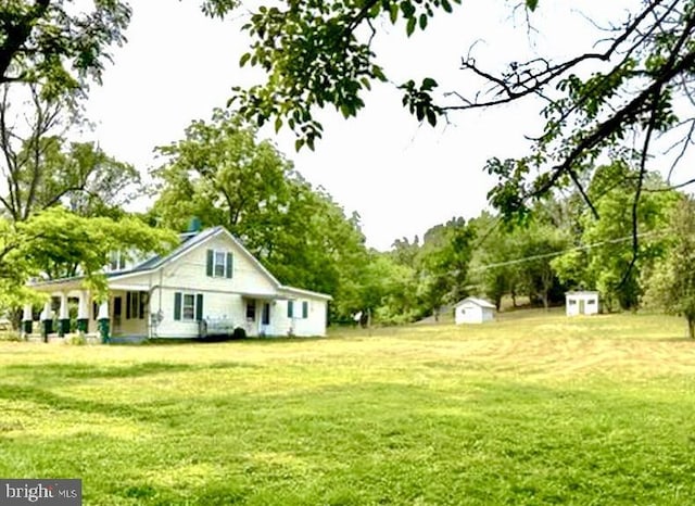 view of yard featuring covered porch and a storage shed