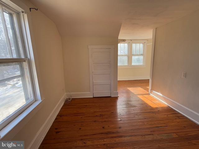 additional living space with dark hardwood / wood-style flooring