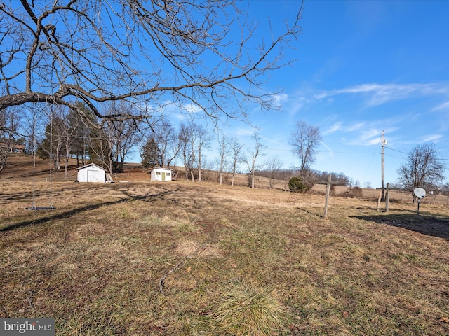 view of yard featuring a rural view and a storage unit