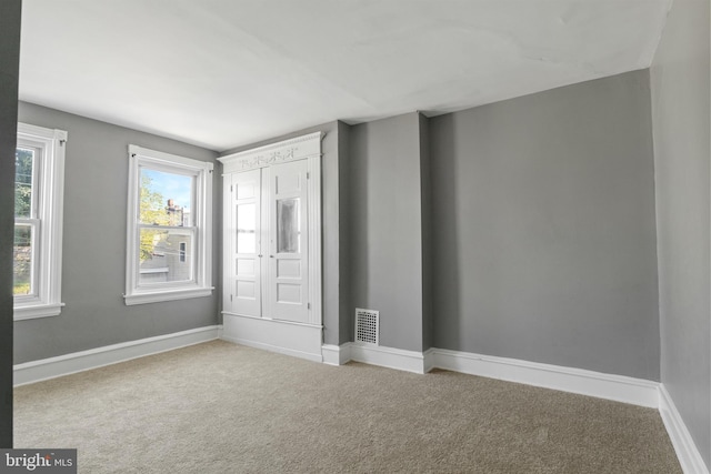 carpeted spare room with a healthy amount of sunlight