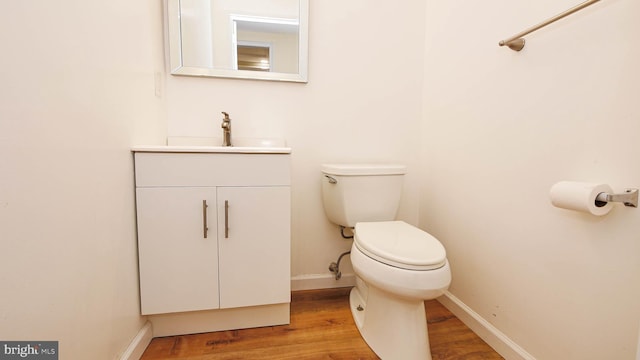 bathroom featuring vanity, toilet, and hardwood / wood-style floors