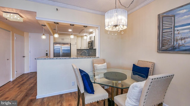 dining area featuring crown molding, dark hardwood / wood-style flooring, a chandelier, and sink