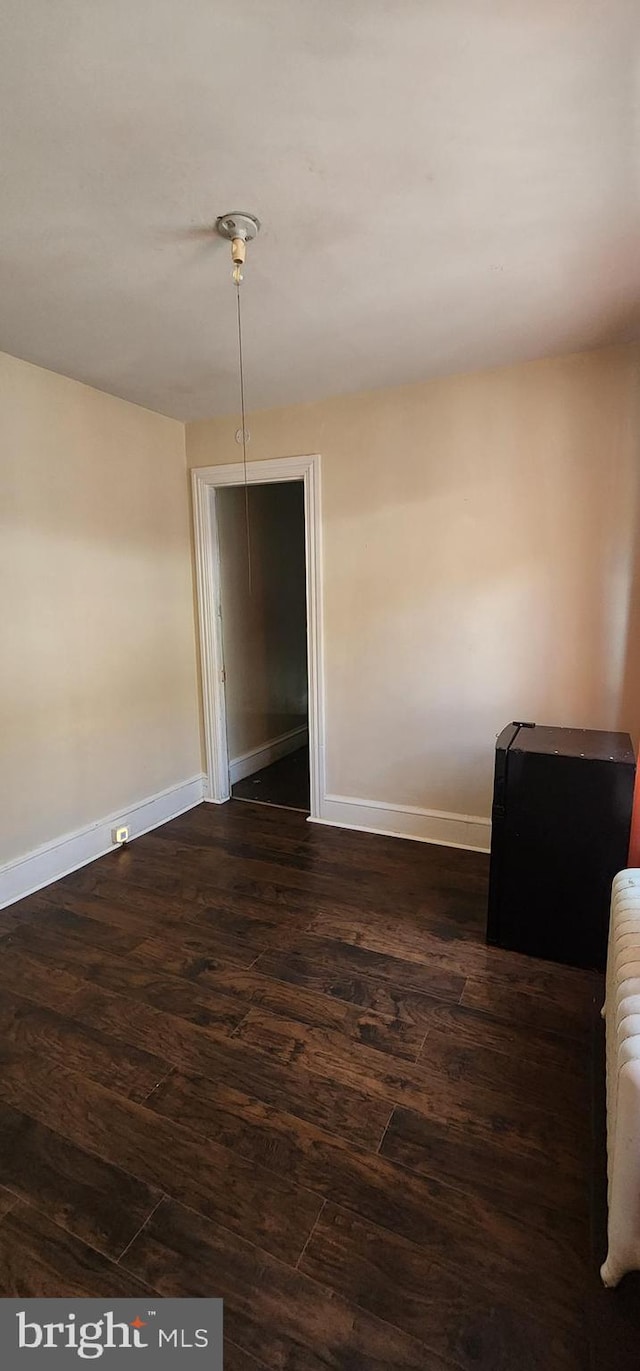 unfurnished room featuring dark hardwood / wood-style flooring