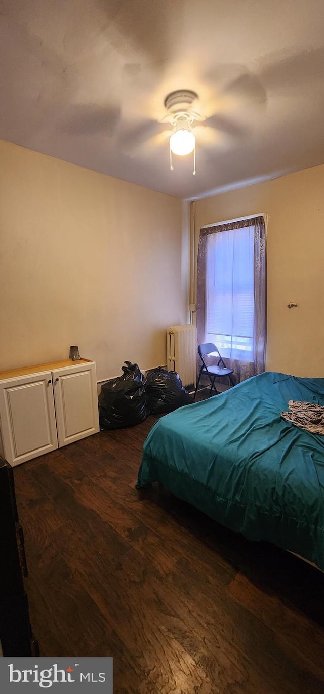 bedroom featuring radiator, dark hardwood / wood-style floors, and ceiling fan