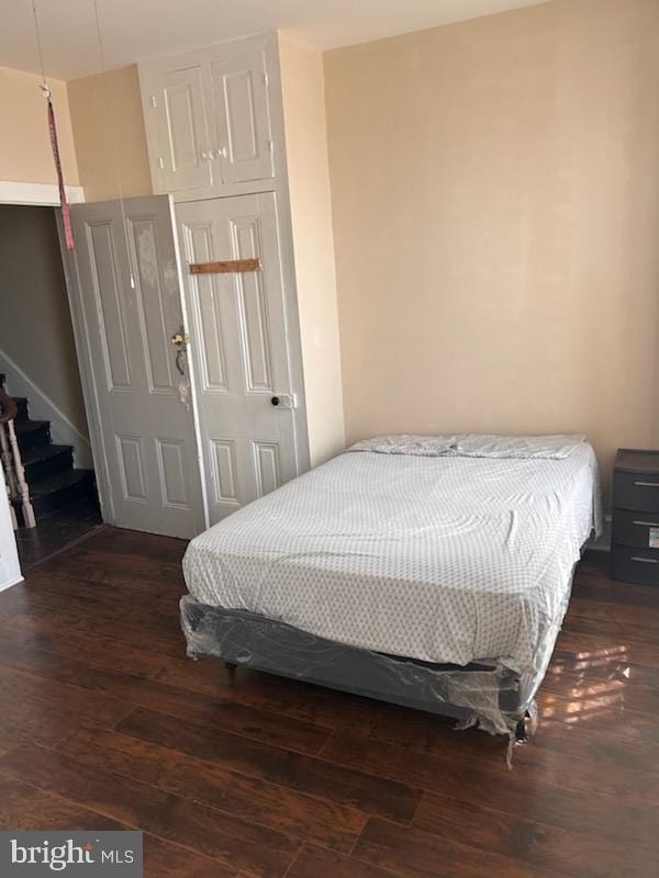 bedroom featuring a closet and dark wood-type flooring