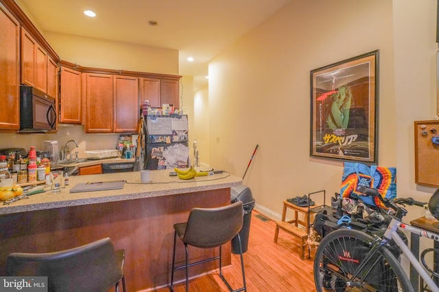 kitchen featuring a breakfast bar, light hardwood / wood-style floors, and sink