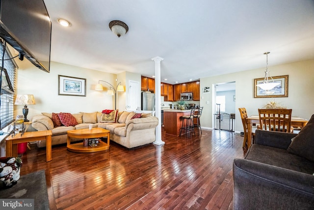 living room with dark hardwood / wood-style floors and ornate columns