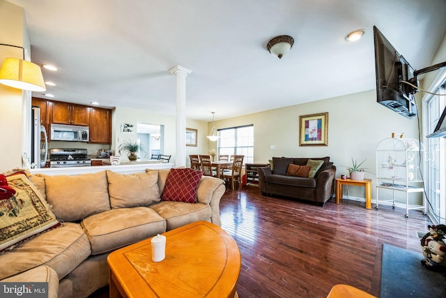 living room featuring decorative columns and dark wood-type flooring