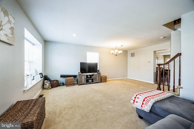 living room featuring carpet floors, an inviting chandelier, and a healthy amount of sunlight