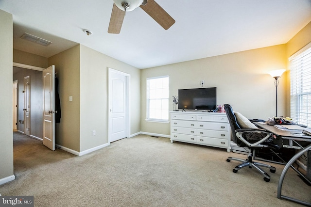 carpeted office featuring ceiling fan and a healthy amount of sunlight