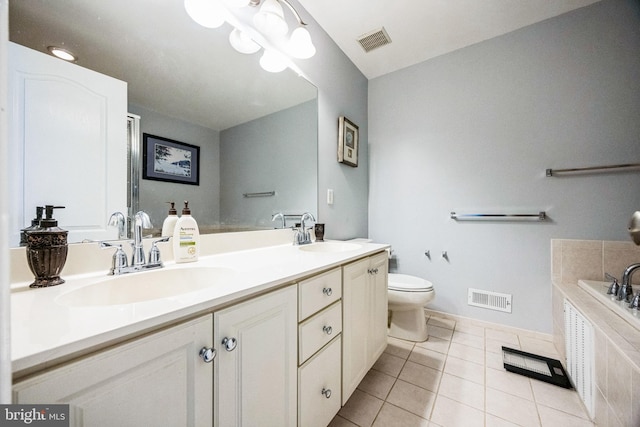 bathroom with tile patterned flooring, vanity, toilet, and a bathing tub