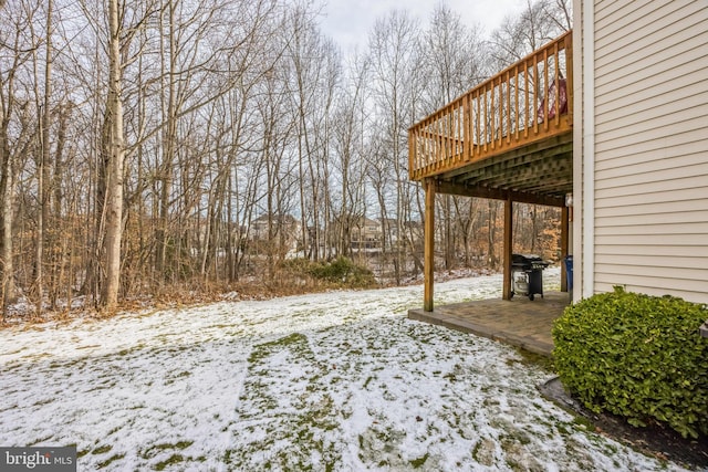 yard covered in snow featuring a deck