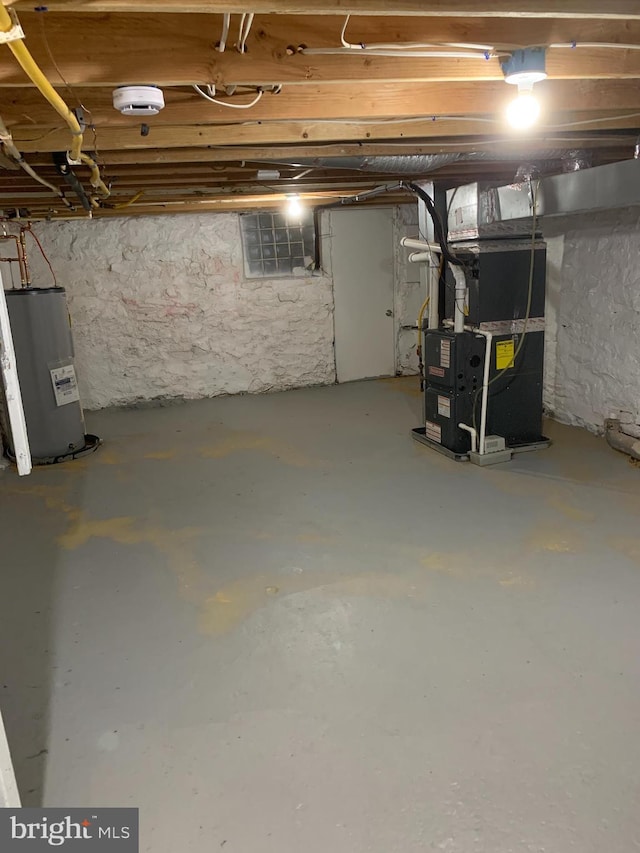 basement featuring heating unit and electric water heater