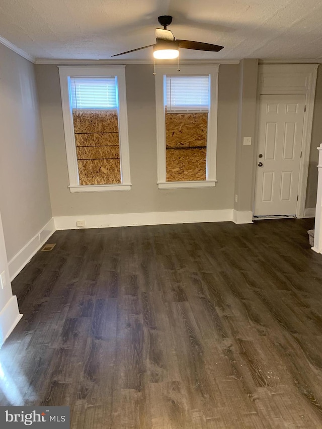 unfurnished room featuring dark wood-type flooring, ornamental molding, and a textured ceiling