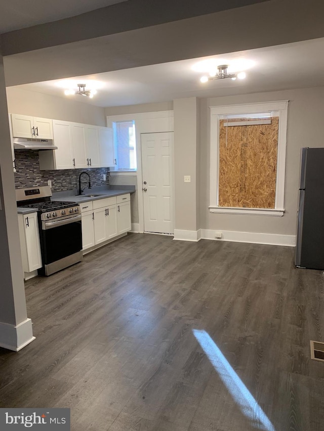 kitchen with sink, dark wood-type flooring, appliances with stainless steel finishes, backsplash, and white cabinets