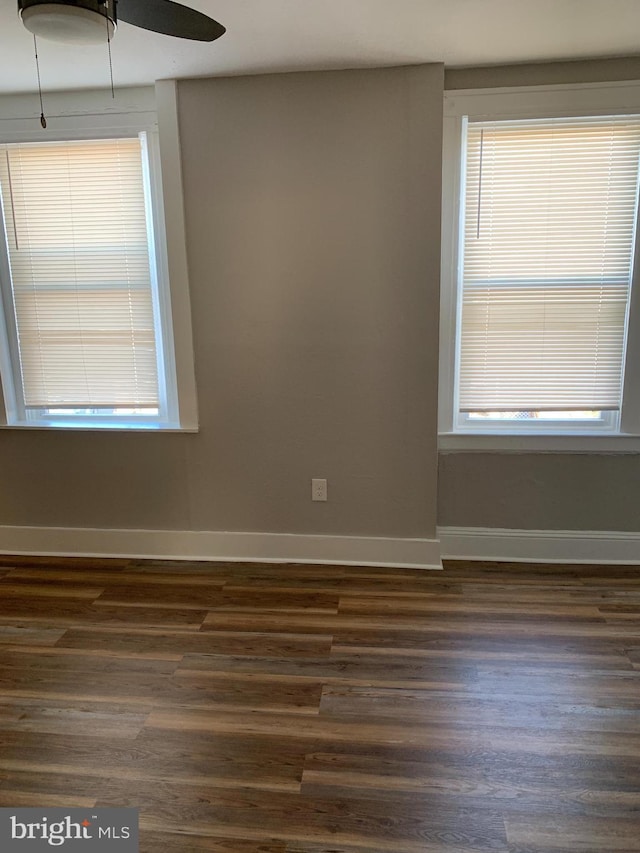 spare room featuring plenty of natural light, dark wood-type flooring, and ceiling fan