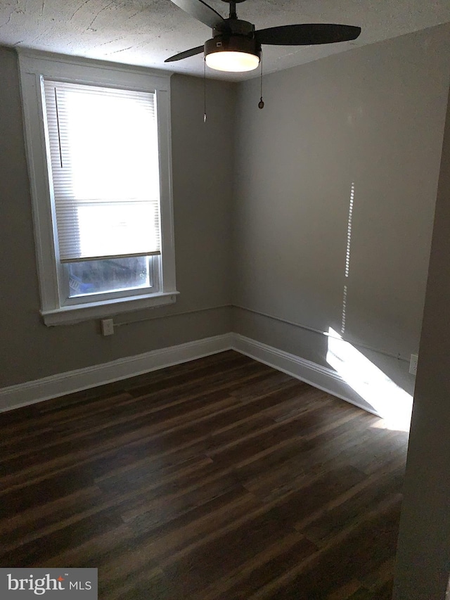 empty room with dark wood-type flooring and ceiling fan