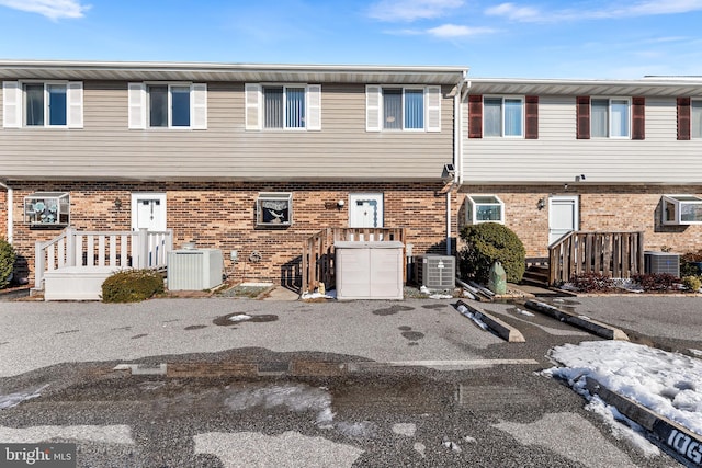 view of property with cooling unit and brick siding