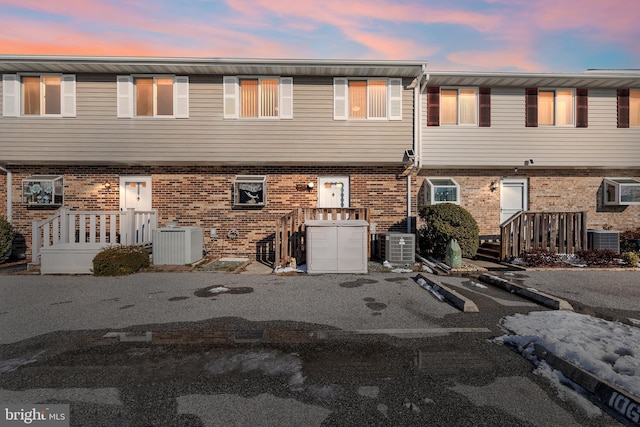 multi unit property featuring cooling unit and brick siding