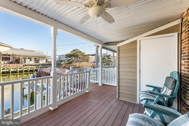 deck featuring a ceiling fan and a water view