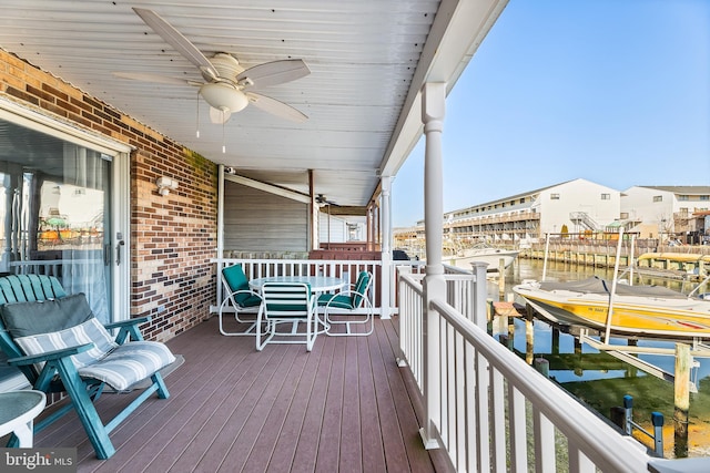 wooden terrace featuring ceiling fan, a boat dock, a water view, and boat lift